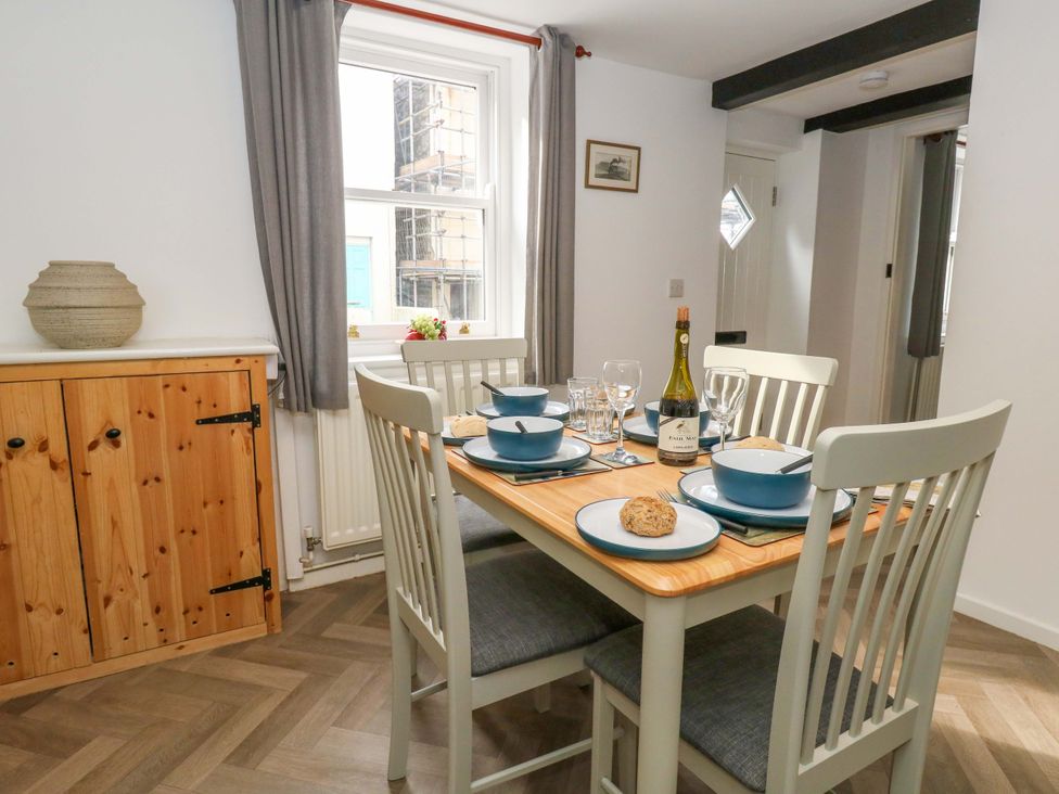 A dining room with a table set for a meal at NO 10 in Fortuneswell