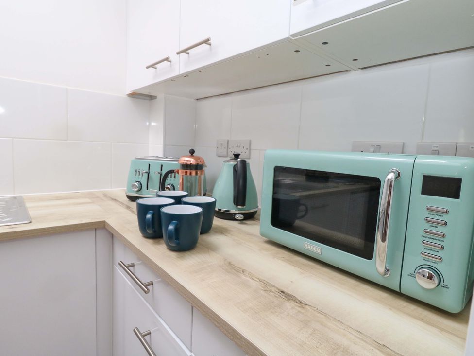 A kitchen with a microwave kettle toaster and cups at NO 10 Fortuneswell