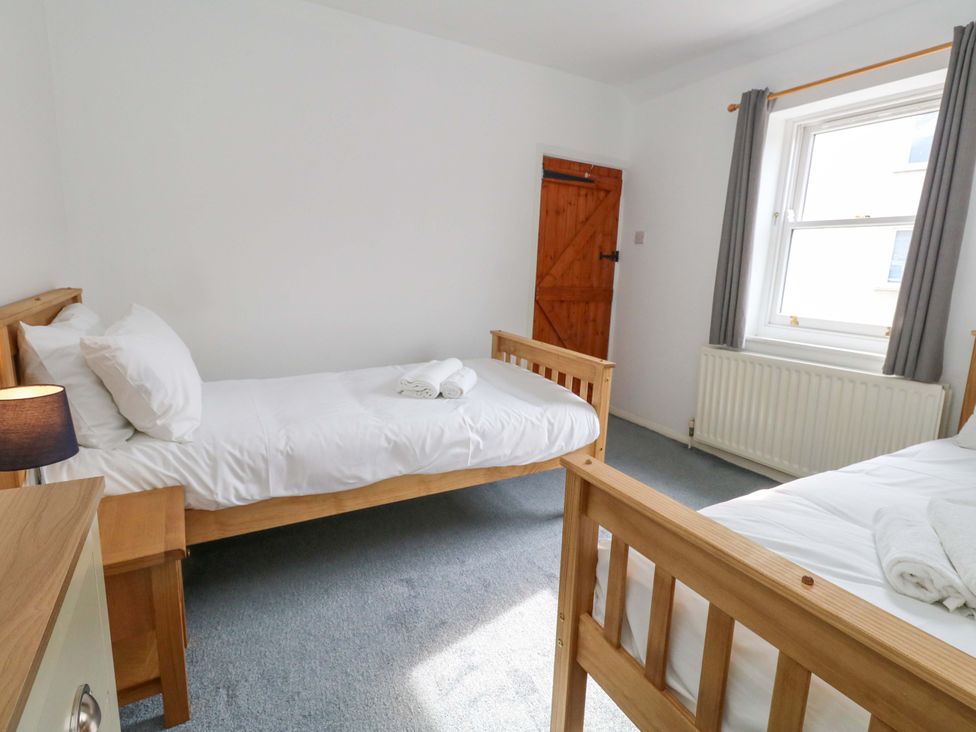 A bedroom with two beds and a window at NO 10 Fortuneswell