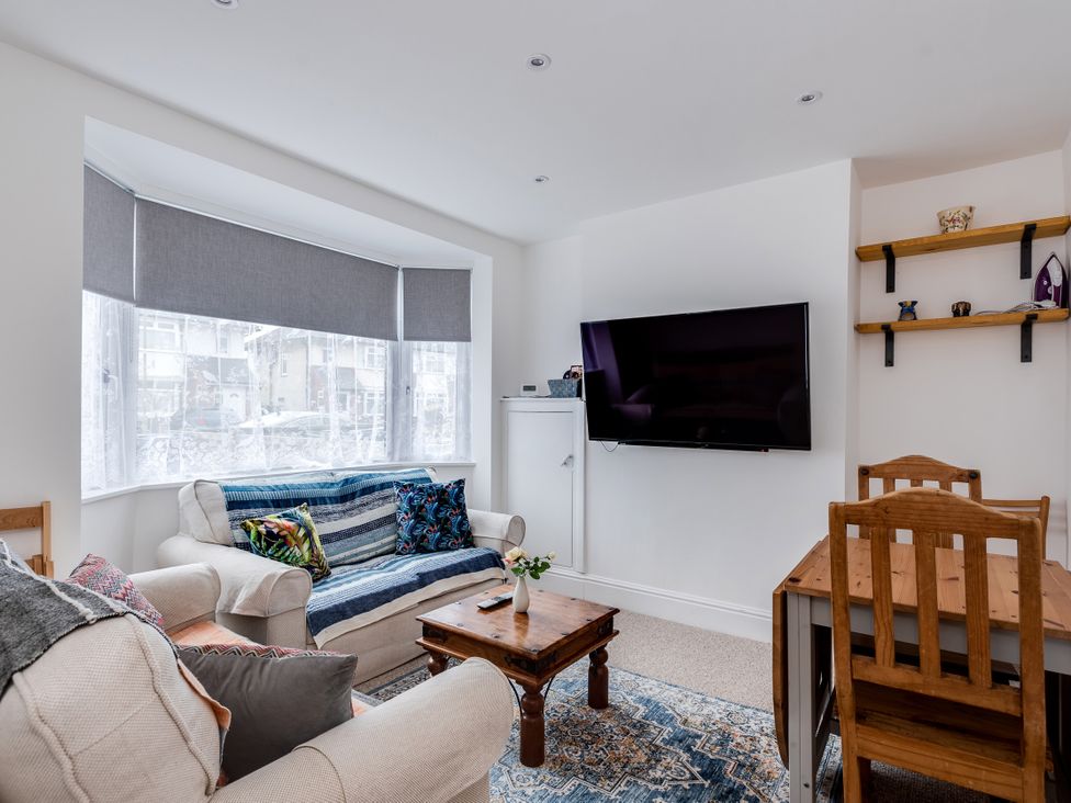 A living room with a sofa, coffee table, and television at Florence of Oxford in Oxford