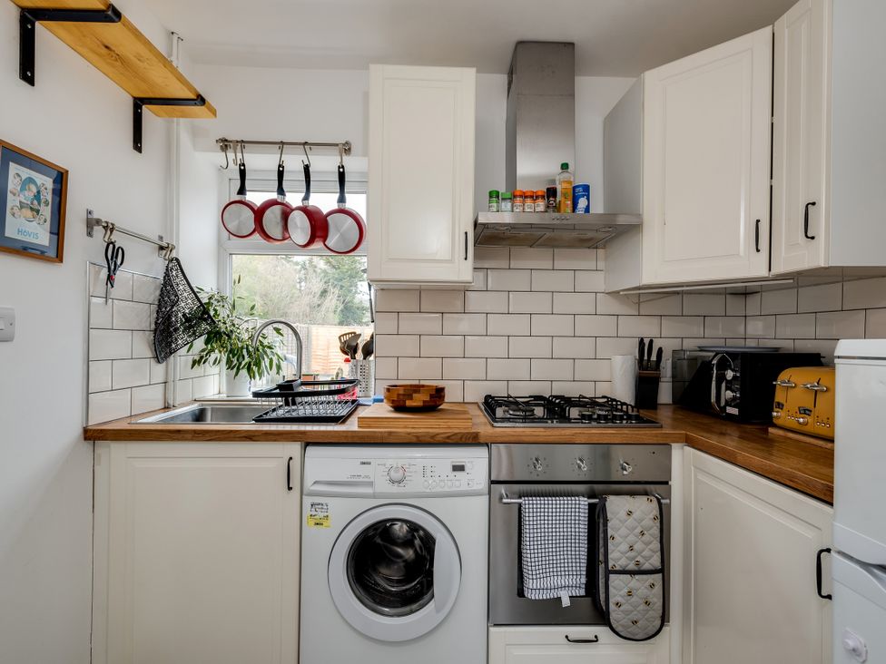 A kitchen with a washing machine, stove, and cabinets at Florence of Oxford, Oxford