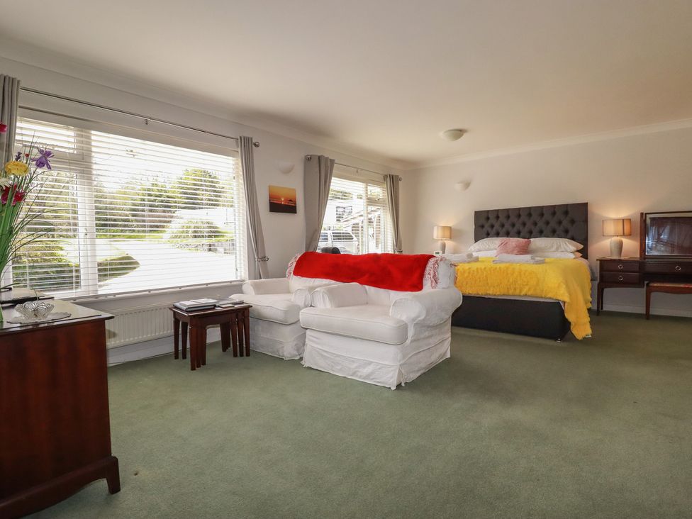 A bedroom with a bed and armchair at Tregoning annex in Lerryn near Lostwithiel
