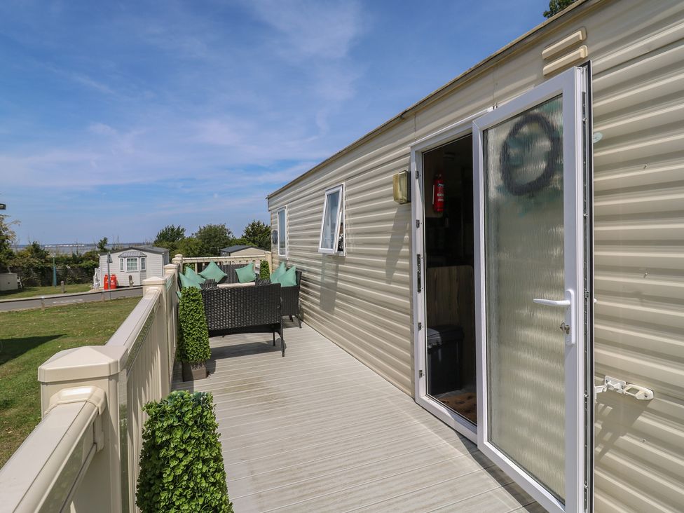 An outdoor space with a deck and seating area at Estuary View in Allhallows