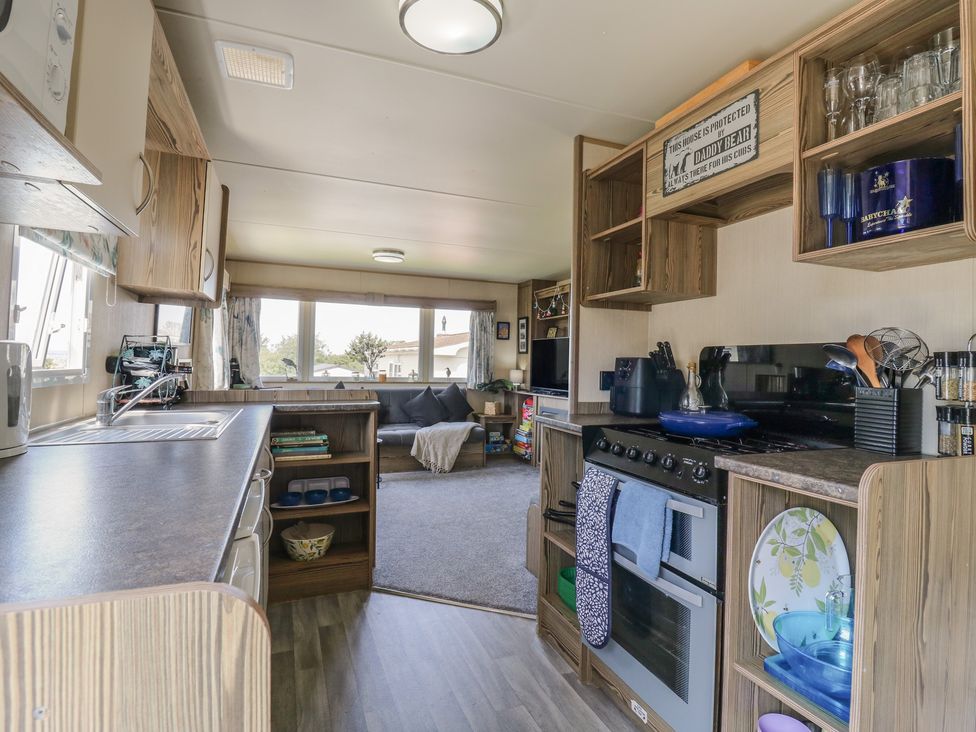 A kitchen with a stove and a dining area at Estuary View in Allhallows