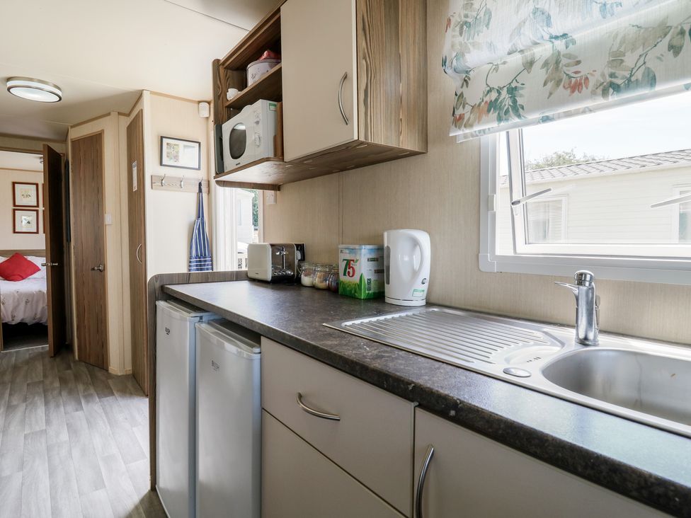 A kitchen with appliances and sink at Estuary View in Allhallows