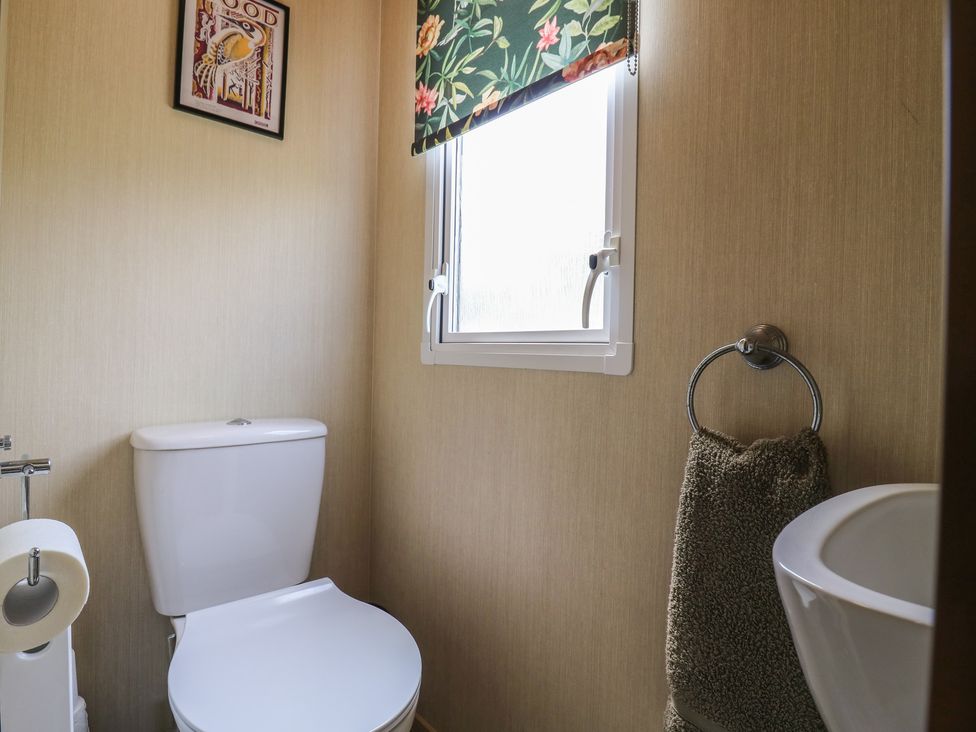 A bathroom with a toilet and a window at Estuary View in Allhallows