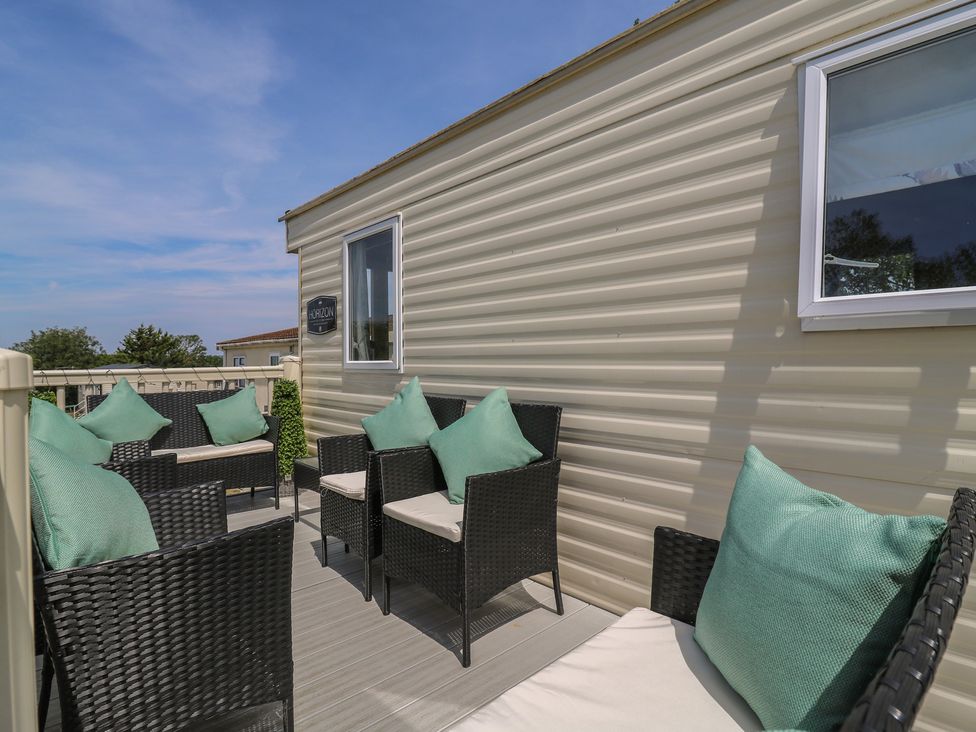 An outdoor seating area with chairs and cushions at Estuary View in Allhallows