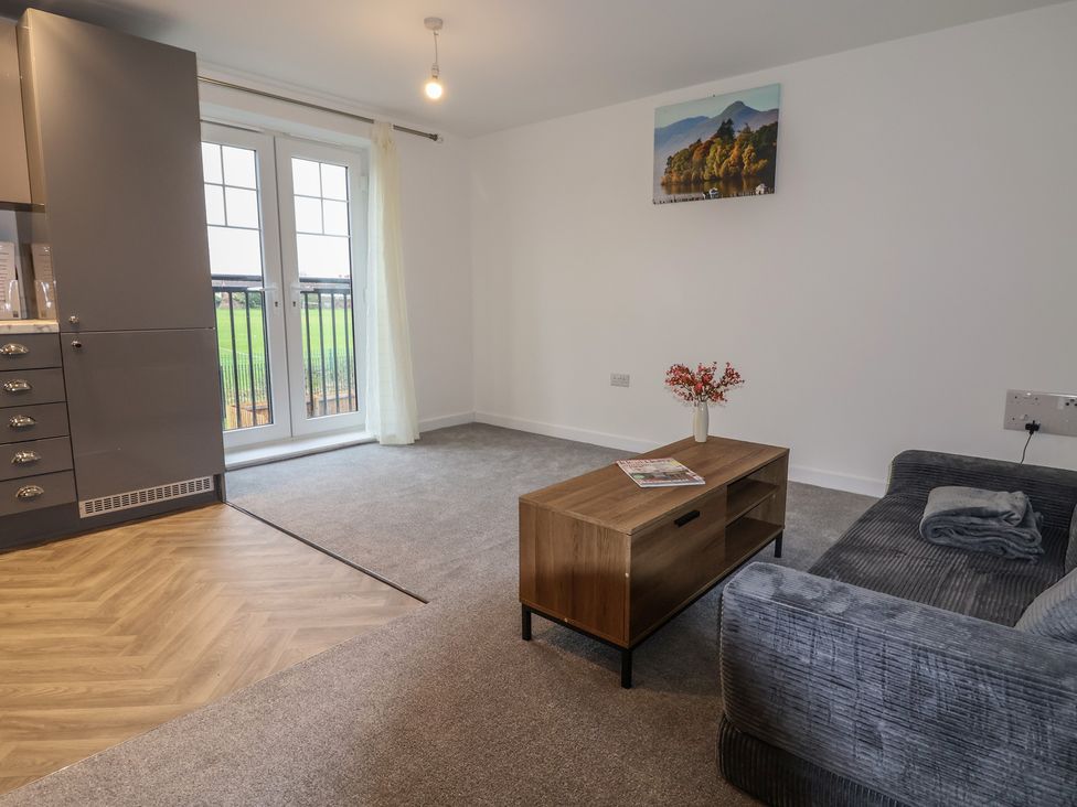 A living room with a coffee table and balcony doors at Apartment 7 at Anfield in Liverpool