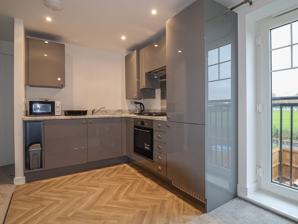 A kitchen with cabinets and appliances at Apartment 7 at Anfield, Liverpool