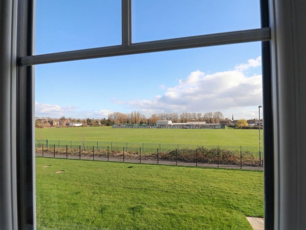 A view of a football pitch with grass and buildings at Apartment 7 at Anfield Liverpool