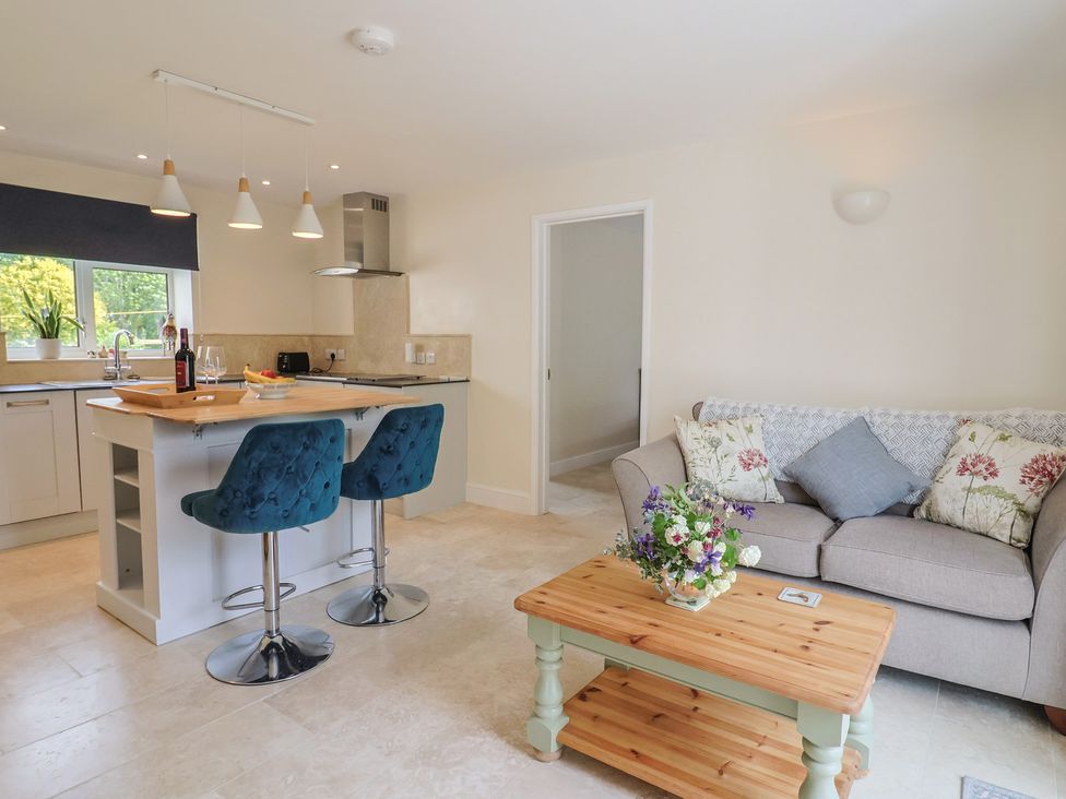 An open plan kitchen and living area with a sofa and coffee table at Harbins Farm in Glanvilles Wootton Nr. Sherborne