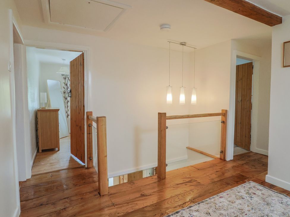 A hallway with wooden flooring and light fixtures at Harbins Farm Glanvilles Wootton Nr. Sherborne
