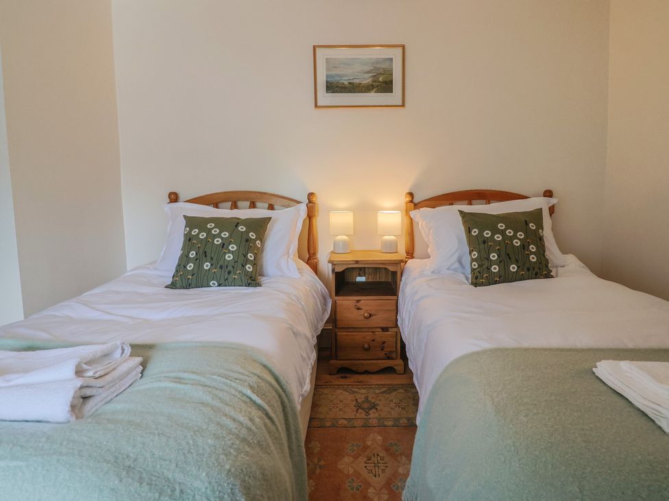 A bedroom with two beds and a bedside table at Harbins Farm Glanvilles Wootton Nr. Sherborne