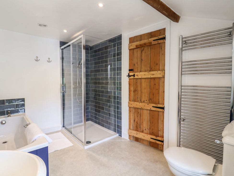 A bathroom with a shower, bathtub and towel rail at Harbins Farm in Glanvilles Wootton Nr. Sherborne