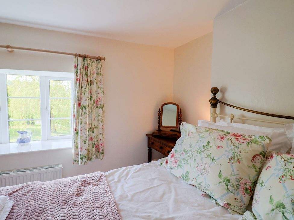 A bedroom with a bed and window at Harbins Farm in Glanvilles Wootton Nr. Sherborne
