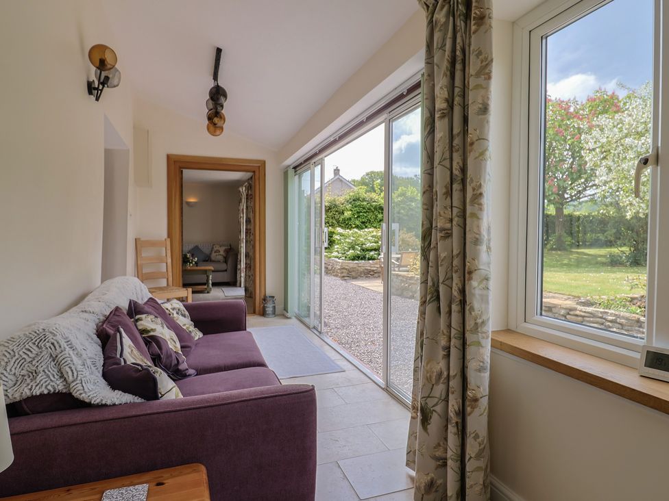 A living room with a sofa and sliding door at Harbins Farm in Glanvilles Wootton Nr. Sherborne