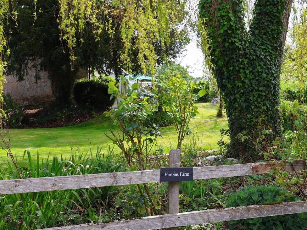 A garden area with trees and a sign at Harbins Farm in Glanvilles Wootton Nr. Sherborne