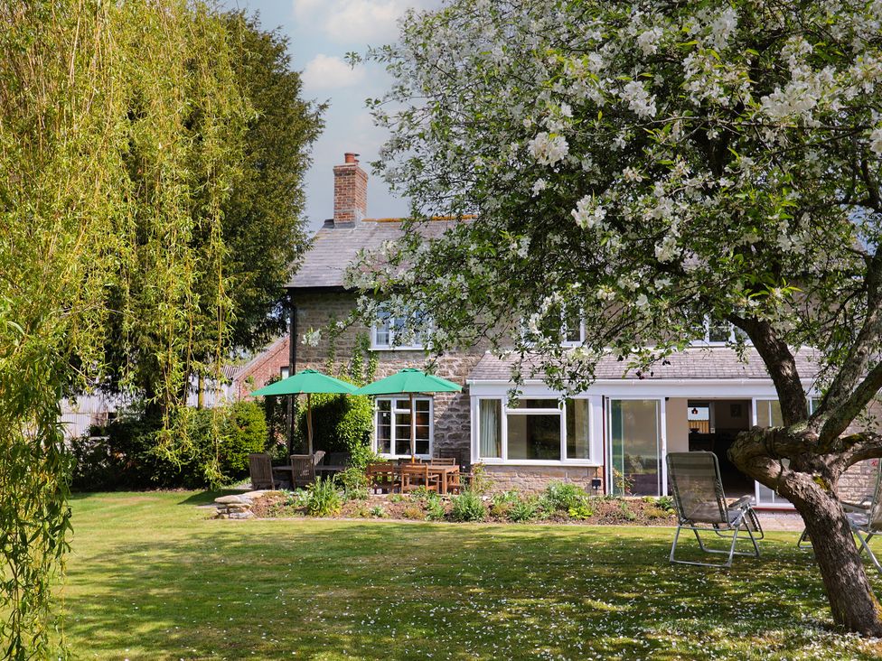 A garden with a house and seating area at Harbins Farm Glanvilles Wootton Nr. Sherborne