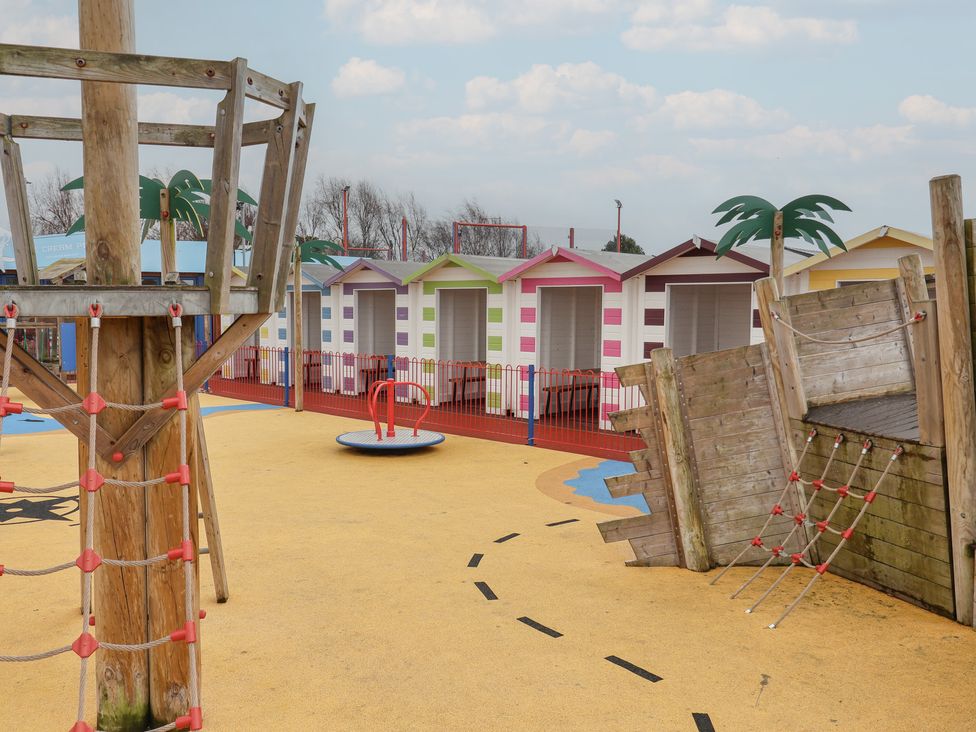 A playground area with playhouses and climbing frames at Winchester - 244