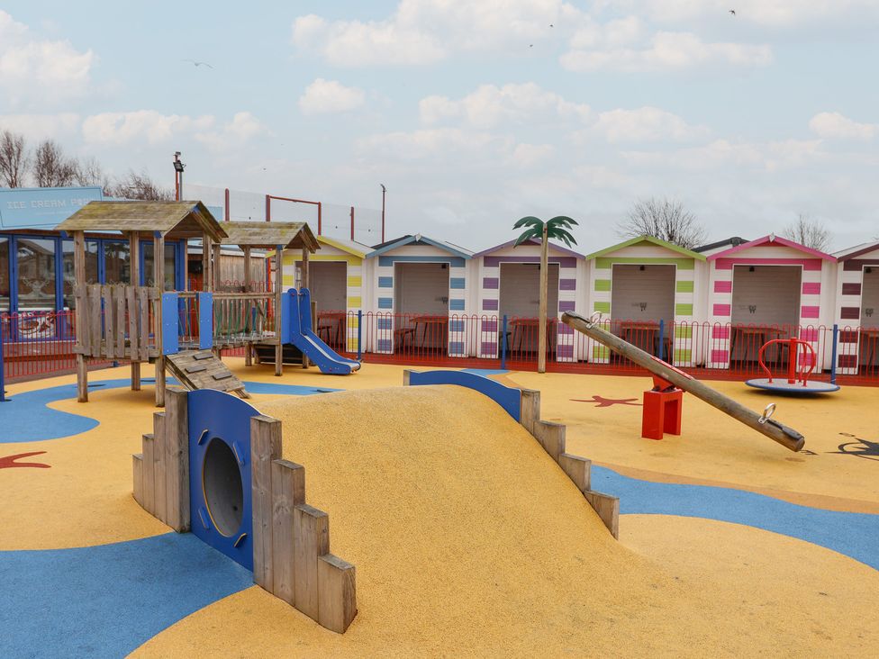 A playground with a slide, sandbox, seesaw and colorful huts at Winchester - 244