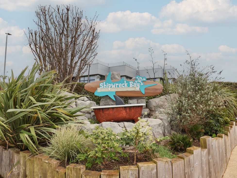 A sign for Shipwreck Bay surrounded by rocks and plants at Shipwreck Bay