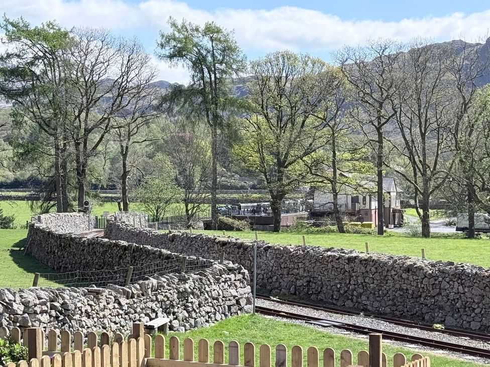 A view of trees and stone walls with a railway track at Pandora in Holmrook