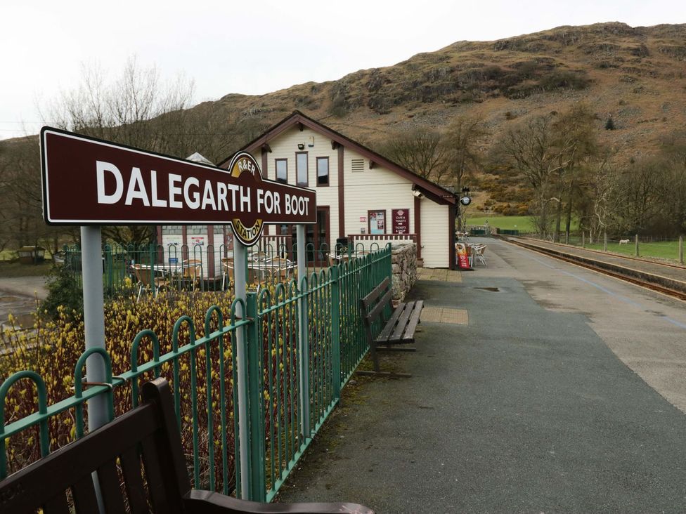 A train station with a sign and a building at Dalegarth for Boot in Holmrook