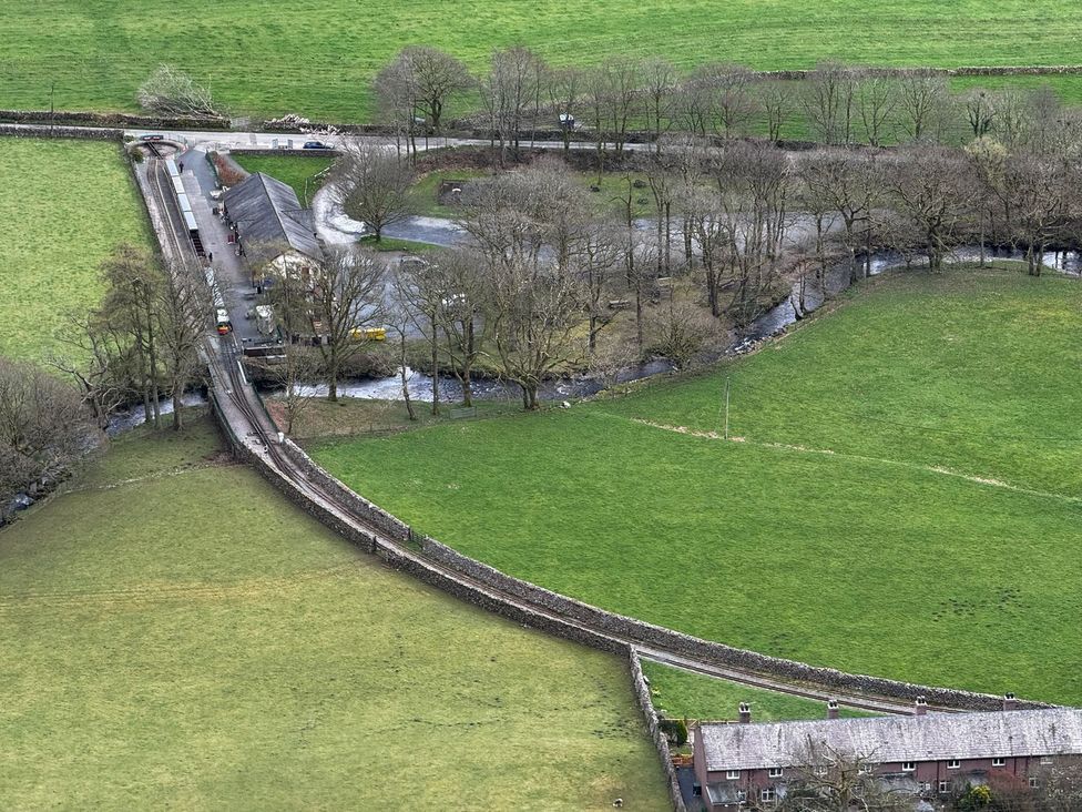 A landscape featuring fields, a bridge, a house near water at Pandora in Holmrook