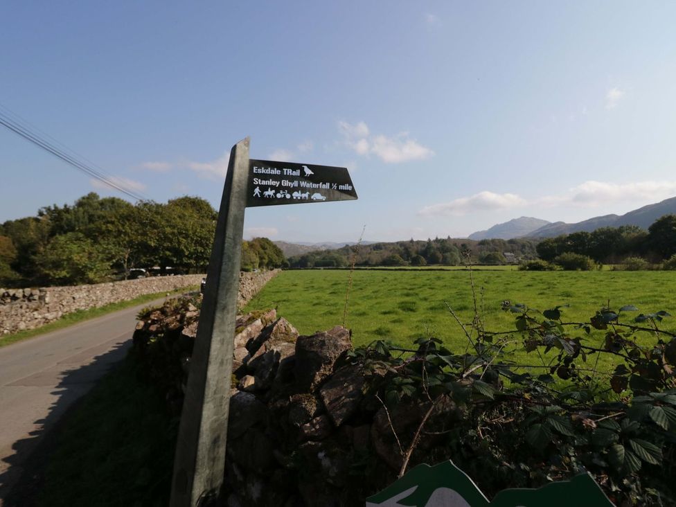A signpost indicating trails near a field at Pandora Holmrook