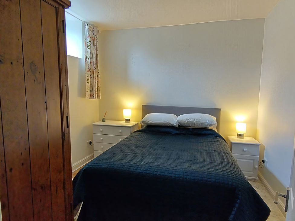 A bedroom with a bed and bedside tables at Linhay Barn in Saltash