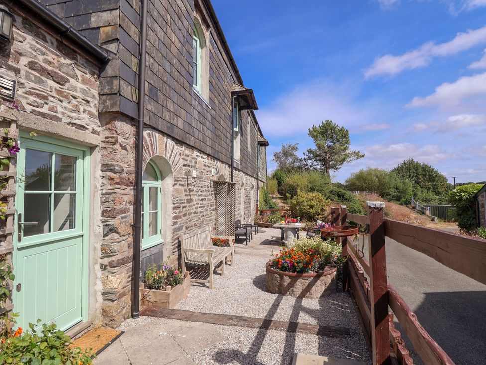 An outdoor area with a bench and table at Linhay Barn Callington
