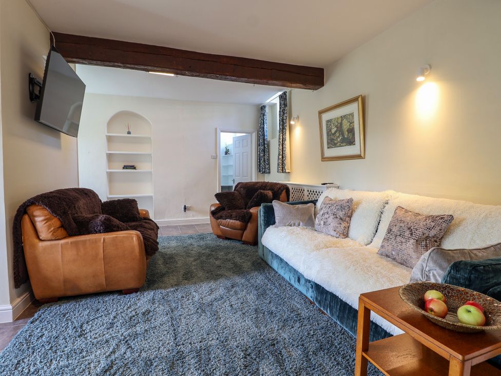 A living room with a sofa and armchairs at Linhay Barn Callington