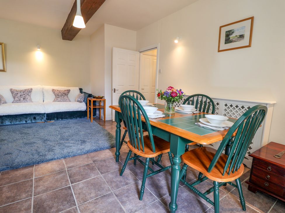 A dining room with a table and chairs at Linhay Barn in Callington