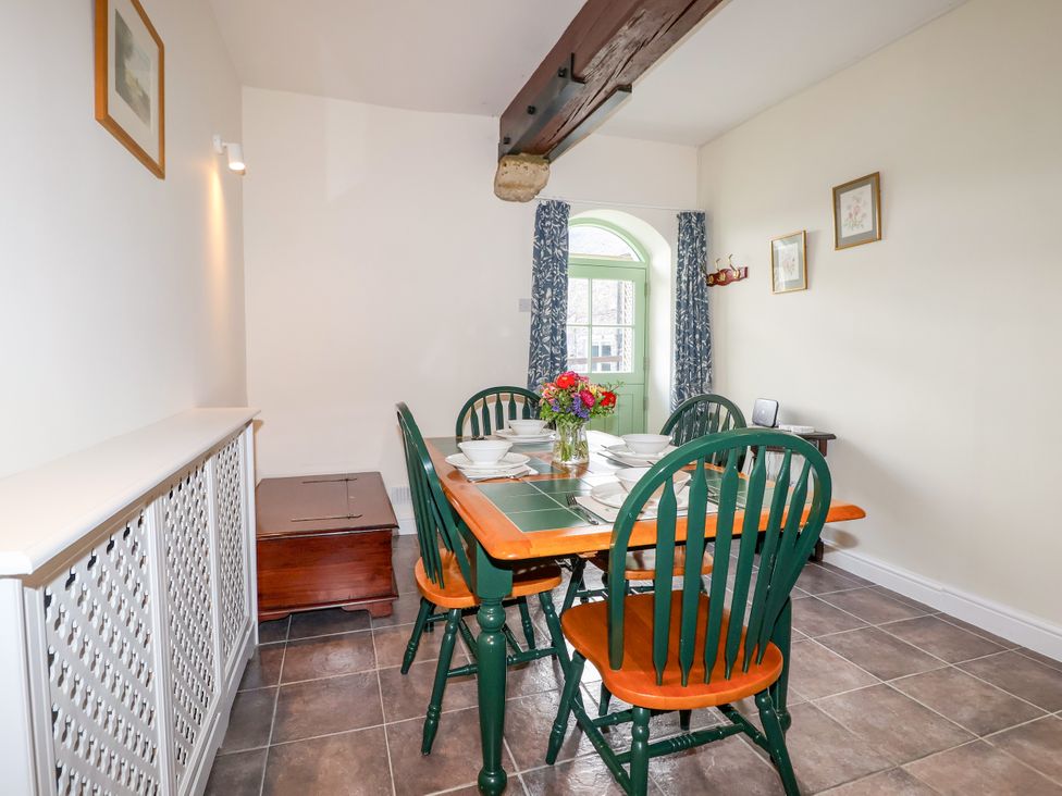 A dining room with a table set for meals at Linhay Barn Callington