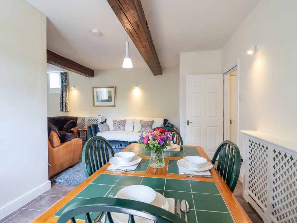 A dining area with a table and chairs at Linhay Barn in Callington