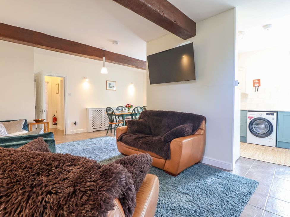 A living room with a sofa and television at Linhay Barn in Callington