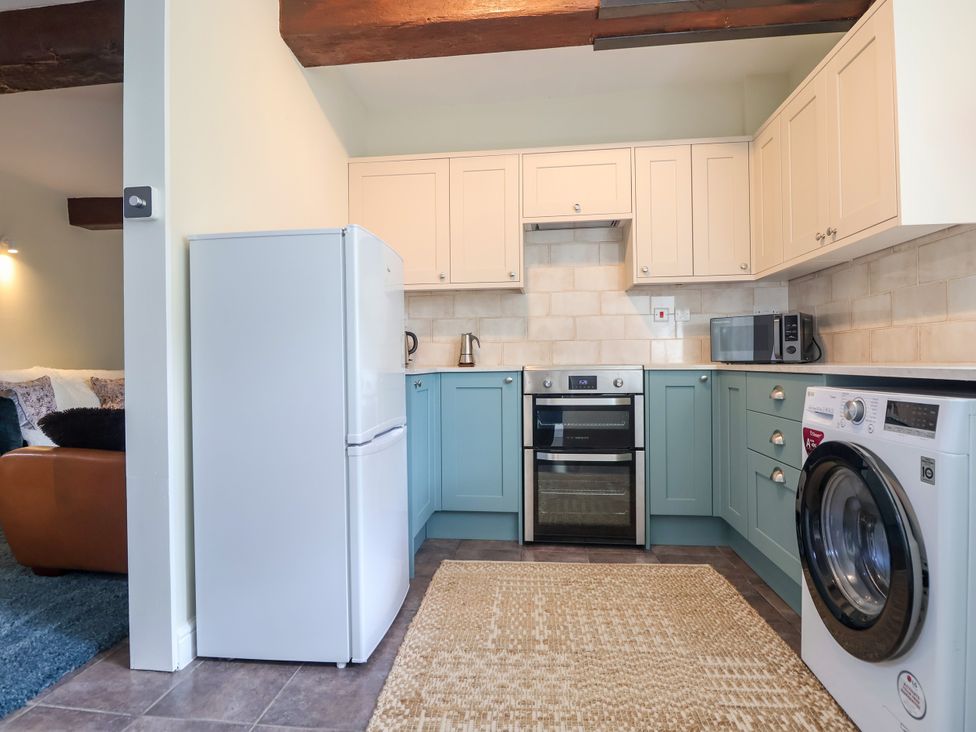 A kitchen with appliances and cabinets at Linhay Barn Callington