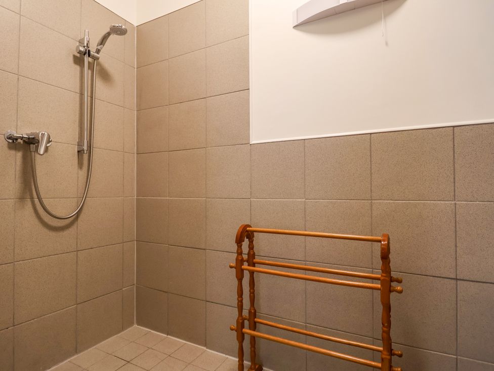 A shower with a towel rack in the bathroom at Linhay Barn Callington