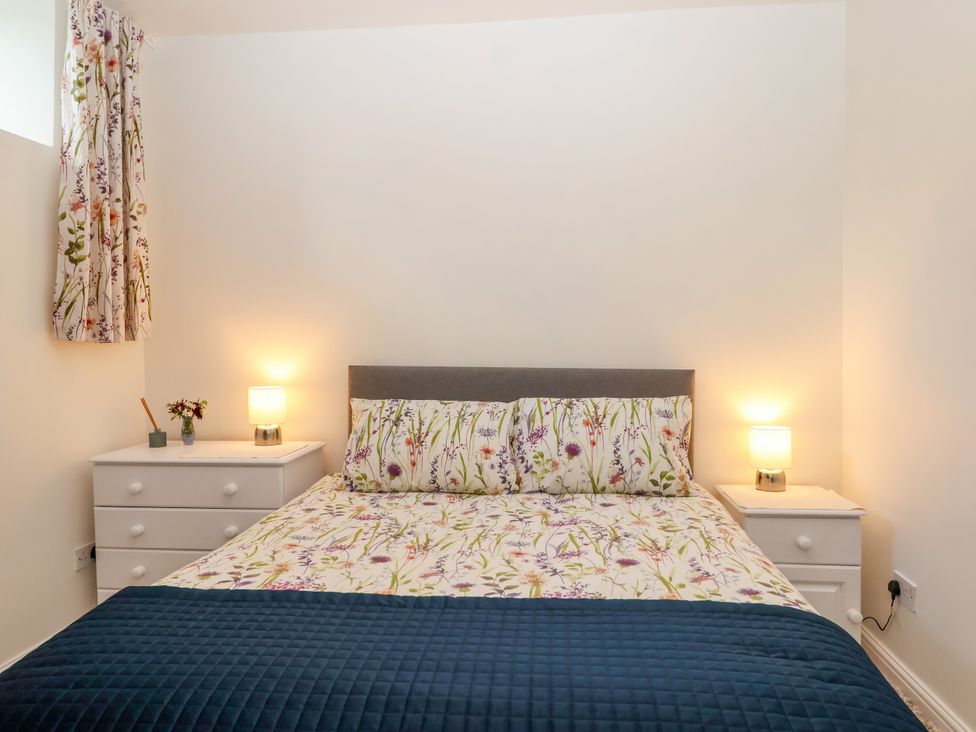 A bedroom with a bed and bedside tables at Linhay Barn in Callington