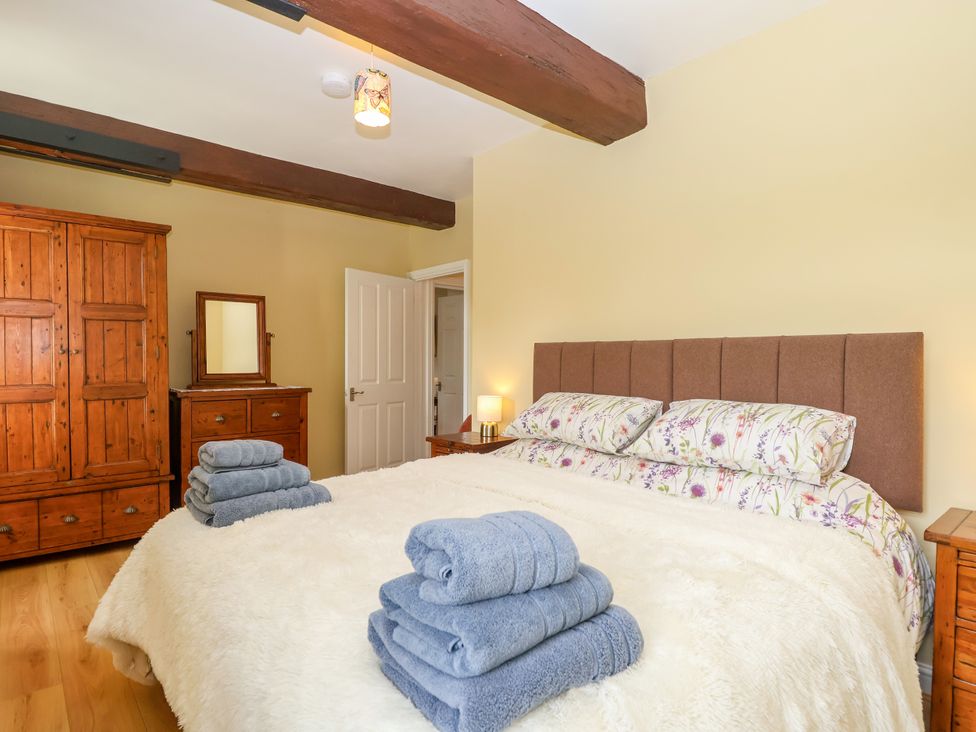 A bedroom with a large bed and furniture at Linhay Barn in Callington