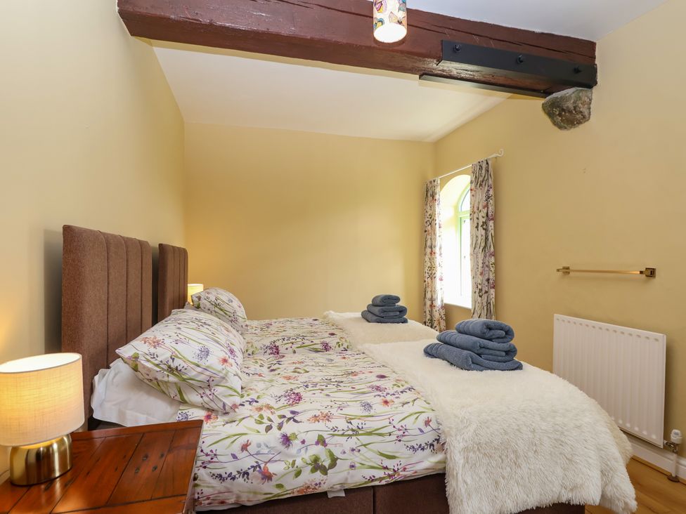A bedroom with two beds and towels on top at Linhay Barn in Callington
