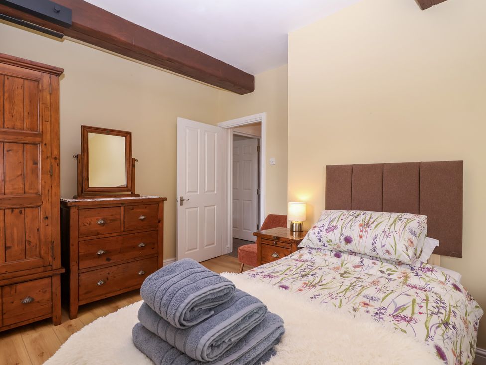 A bedroom with a bed and furniture at Linhay Barn in Callington