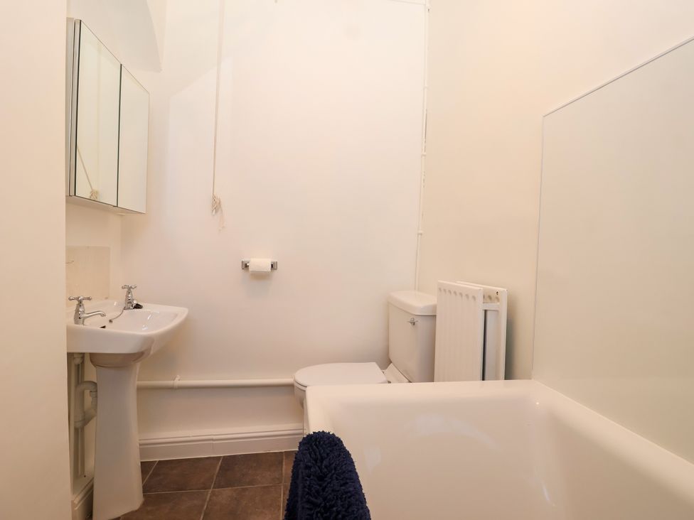A bathroom with a sink, toilet, and bath tub at Linhay Barn Callington