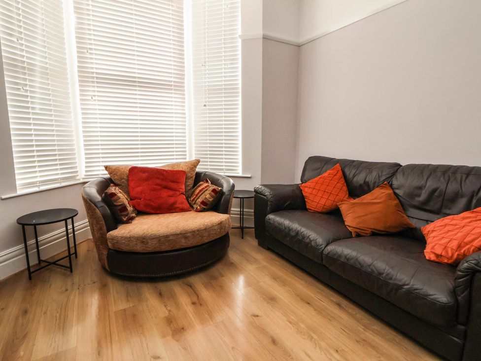 A living room with a sofa and armchair at Seaside Home in New Brighton