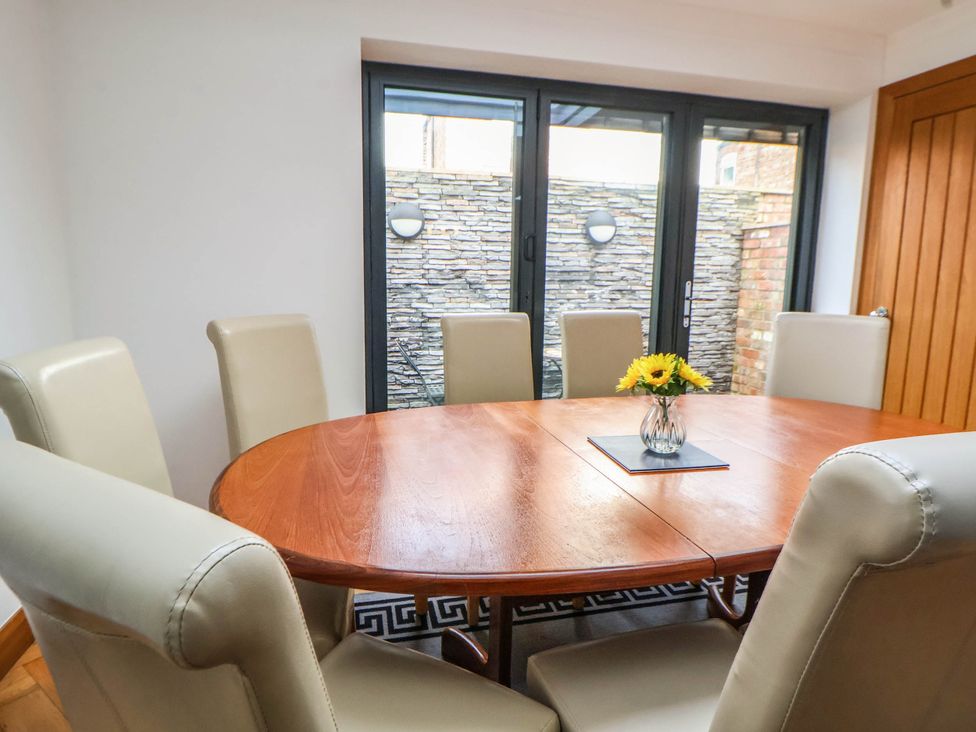 A dining room with a round table and chairs at Seaside Home in New Brighton