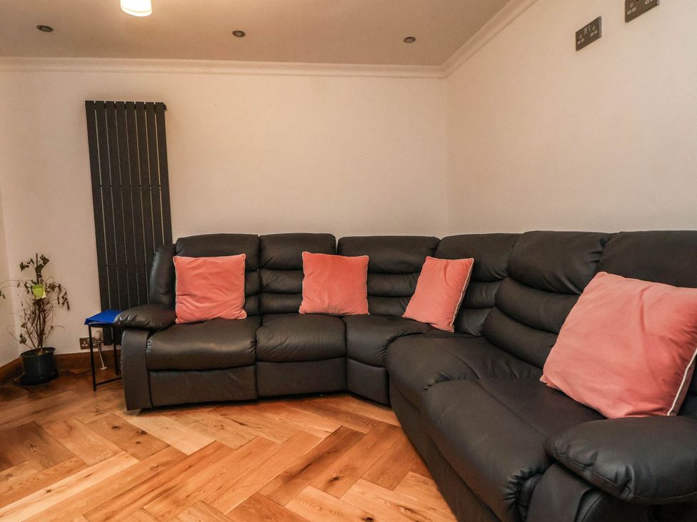 A living room with a corner sofa and cushions at Seaside Home in New Brighton
