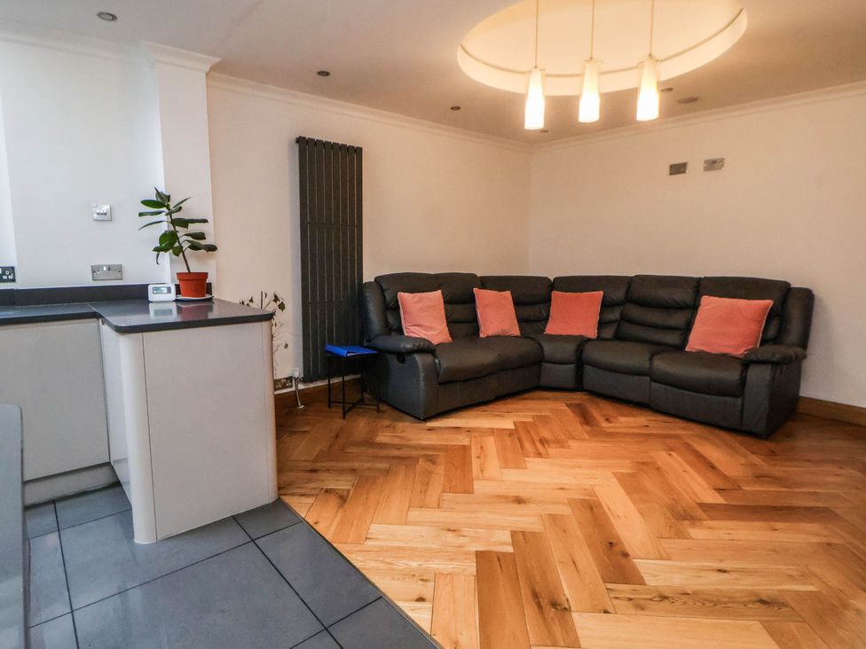 A living room with a sofa and cushions at Seaside Home in New Brighton