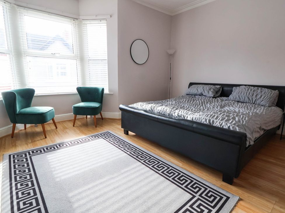 A bedroom with a bed and chairs at Seaside Home in New Brighton