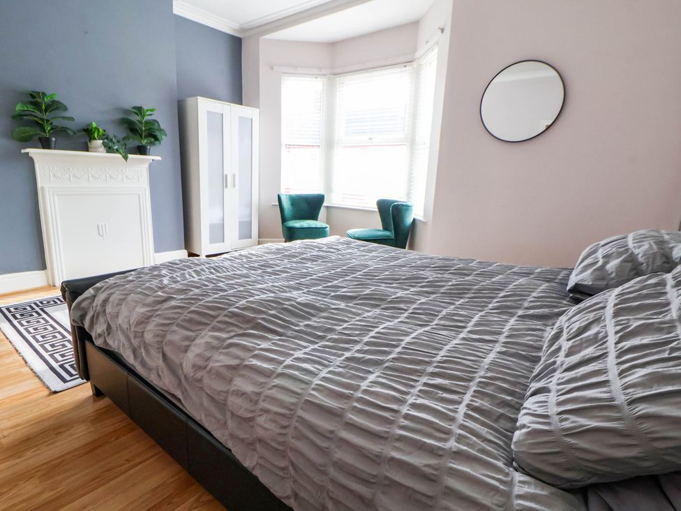 A bedroom with a bed and wardrobe at Seaside Home in New Brighton