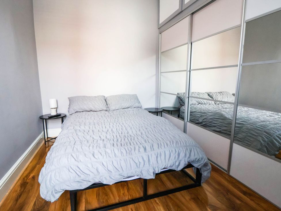 A bedroom with a bed and nightstand at Seaside Home in New Brighton